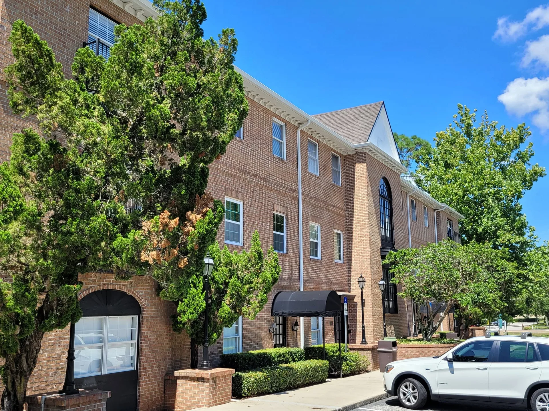 Three story brick office building white gutters black awning, Lake Mary